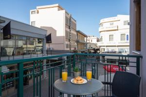 a table with a plate of food on a balcony at Mirma City apartment2 Old Town in Chania