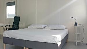 a bed with two pillows and a chair in a room at Motel Tiny House in Nitra