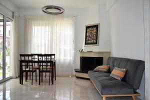 ein Wohnzimmer mit einer Couch und einem Tisch und Stühlen in der Unterkunft Kýma Seafront House in Patras