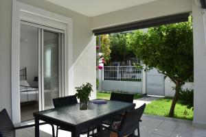 a patio with a table and chairs and a sliding glass door at Kýma Seafront House in Patra