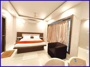 a bedroom with a bed and a chair and a window at HOTEL HOME # TOWN Near Jagannath Temple - Sea Beach - Fully Air conditioned & Spacious Luxuary Rooms - Free Wifi & Parking Facilitie in Gaya