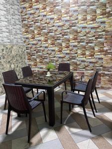 a table and chairs in a room with a brick wall at Жилье на природе с бассейном in Tashkent