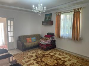 a living room with a couch and a chandelier at Жилье на природе с бассейном in Tashkent
