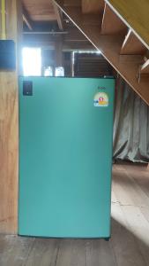 un réfrigérateur bleu placé à l'intérieur d'un bâtiment dans l'établissement Relax House, à Ko Phayam