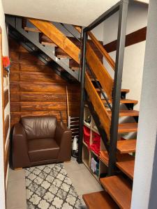 a living room with a couch and a staircase at Chata Jakub in Mýto pod Ďumbierom