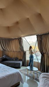 a woman standing in front of a window in a hotel room at Rum Rhal Luxury Camp in Aqaba +25 photos