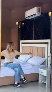 a woman sitting on top of a bed at Rum Rhal Luxury Camp in Aqaba +2 photos