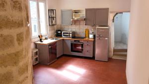 a kitchen with stainless steel appliances in a room at Magnifique appartement cours Jean Jaurès Climatisée in Pézenas +3 photos