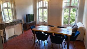 a living room with a wooden table and chairs at Magnifique appartement cours Jean Jaurès Climatisée in Pézenas