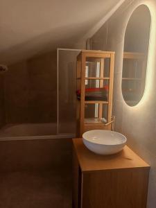 a bathroom with a bowl sink on a wooden cabinet at Magnifique appartement cours Jean Jaurès Climatisée in Pézenas