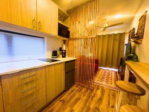 a kitchen with wooden cabinets and a wooden floor at The Zanzibar Beach House-South in Bwejuu