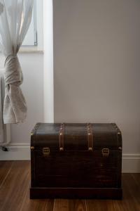 un vecchio baule appoggiato sul pavimento accanto a una finestra di CAMERA a TERMINI GIOBERTI a Roma
