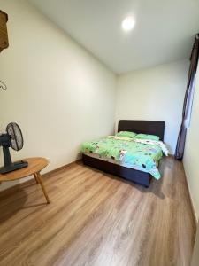 a small bedroom with a bed and a table at Rich field Cameron Highlands Homestay-Peony Square-3BDR 2BTH-8PAX in Cameron Highlands