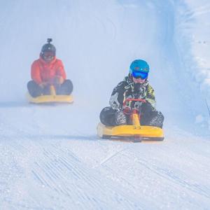 two people riding snowboards down a snow covered slope at Hytte anno 1721 uten internett, strøm, vann - men med rødmalt utedo in Ljørdal