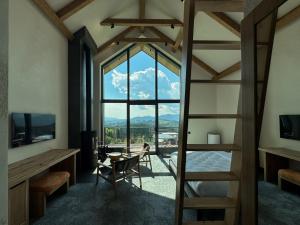 Charlton Estate في يابلونيتسيا: غرفة مع نافذة كبيرة مع طاولة وكراسي