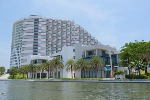 Cam Ranh International AirportにあるArena Cam Ranh - Luxury Apartment Sea Viewの水の前のヤシの木の建物