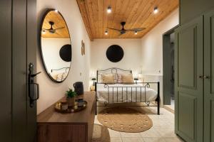 a bedroom with a bed and a mirror at Petronikoli Traditional House in Choudetsi +37 photos