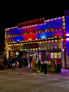a building with people standing outside of it at night at Stylish Ensuit Studios in the Heart of Vibrant Tooting 1 Min to Tube in London