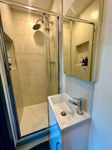 a bathroom with a sink and a shower at Stylish Ensuit Studios in the Heart of Vibrant Tooting 1 Min to Tube in London +12 photos