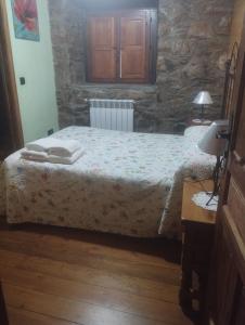 ein Schlafzimmer mit einem Bett und einer Steinwand in der Unterkunft Rincón del Bierzo in Borrenes + 6 Fotos