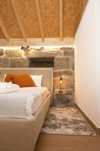 a bedroom with a bed and a stone wall at Retiros do Vale in Vila Real
