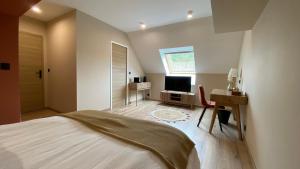 a bedroom with a bed and a desk and a television at Une parenthèse Terracotta 