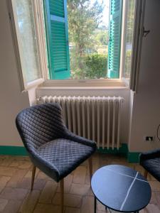 a room with two chairs and a table and a window at B&B Villa Lory in Fara Filiorum Petri