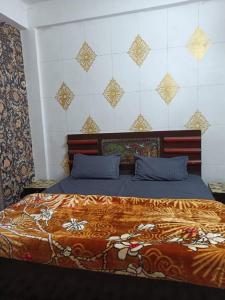 a bedroom with a large bed with blue pillows at Shri premanand g niwas Sthan in Vrindāvan