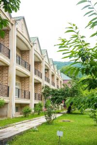 a row of apartment buildings with a green yard at Cennet Bagi Guba Hotel in Quba