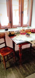 uma mesa com livros ao lado de uma cadeira em Vándor Kakas Vendégház dézsafürdővel em Recsk