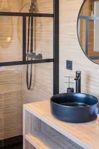 a bathroom with a black sink and a mirror at Villa Naval 47 Vue Majestueuse Orb et Mer in Valras-Plage
