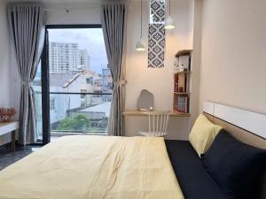 a bedroom with a large bed and a large window at Four P Stay Phu Nhuan in Ho Chi Minh City
