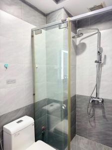a bathroom with a glass shower with a toilet at Four P Stay Phu Nhuan in Ho Chi Minh City +32 photos