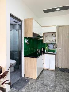 a green kitchen with a sink and a toilet at Four P Stay Phu Nhuan in Ho Chi Minh City