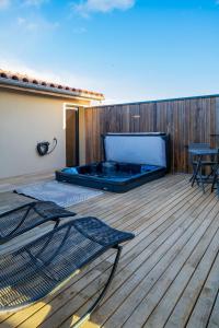 a hot tub sitting on top of a wooden deck at Villa Naval 47 Vue Majestueuse Orb et Mer in Valras-Plage