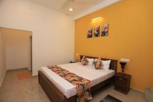 a bedroom with a large bed with yellow walls at Villa ONE66 in Dambulla