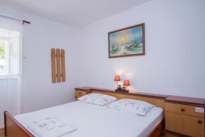 - une chambre avec un lit et une photo sur le mur dans l'établissement Radovčić Apartments and Rooms, à Trsteno