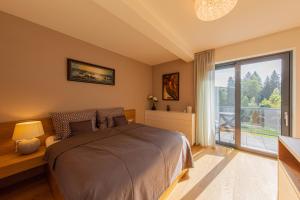 a bedroom with a bed and a large window at Apartmán Silvie Luhačovice in Luhačovice