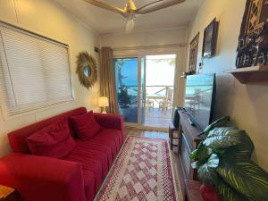 een woonkamer met een rode bank en een tv bij The Zanzibar Beach House-North in Bwejuu +33 foto's