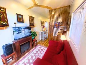 een woonkamer met een rode bank en een tv bij The Zanzibar Beach House-North in Bwejuu