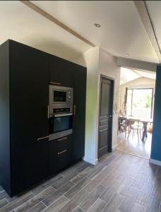 eine Küche mit schwarzen Schränken und einer Mikrowelle in der Unterkunft Appartement proche des plages in Bidart