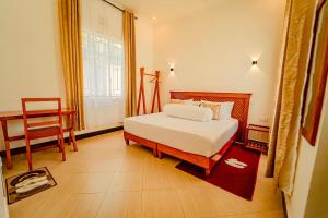 a bedroom with a bed and a chair and a window at Maasai Villa in Arusha