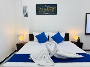 a bed with two towels in the shape of a heart at AP Pearl Palace -Tangalle in Tangalle