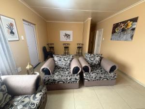 ein Wohnzimmer mit zwei Stühlen und einer Couch in der Unterkunft Casa Palm and Tide holiday home in Swakopmund