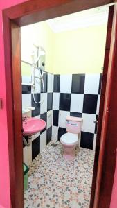 a bathroom with a pink toilet and a sink at Sampheap Guesthouse in Stœ̆ng Trêng +12 photos
