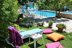 チェシメにあるParla Apart Hotelのテーブルと椅子のある庭、プールを併設しています。