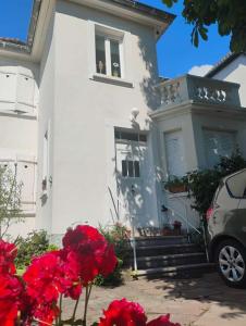 シャトノワにあるGîte avec parking, au calme, entre Colmar-Riquewihr et Obernai ,marchés de Noël, 3 chambres, avec terrasseの赤い花が飾られた白い家