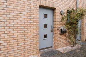 a brick building with a white door and a brick wall at Anubis relaxed&stay in Hamburg
