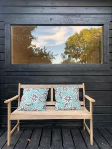a wooden bench with two pillows on a porch at Ancien Prieure Chambre King Size avec sauna et bain nordique privatifs en extérieur in Saint-Merd-les-Oussines +7 photos