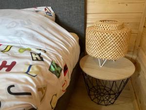 a bed with a rattan nightstand next to a bed at Cottage scandinave 89 in Bourbourg